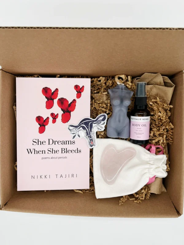 Box filled with items from the I Am Divine Period Care Package from My Club Red including poetry book, uterus sticker, rose quartz gun she stone, goddess candle, body oil and womb connection guided meditation